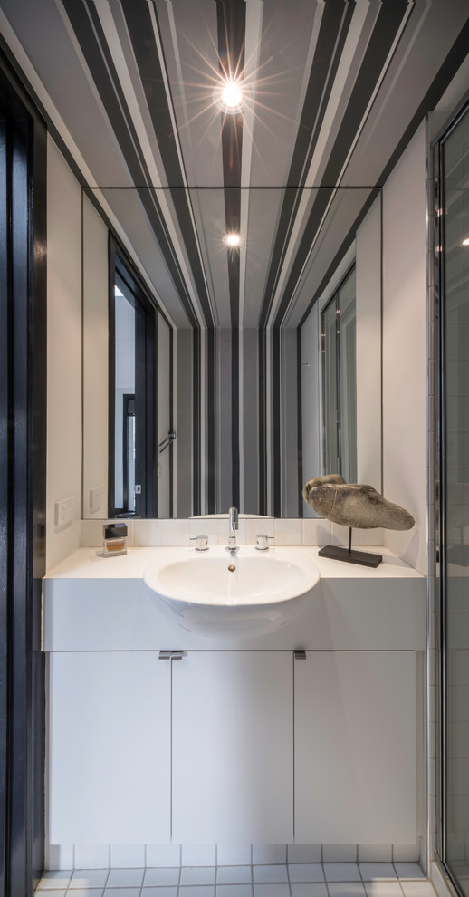 Kleines Modernes Badezimmer mit weißen Schränken, Duschnische, weißen Fliesen, grauer Wandfarbe, Keramikboden und Laminat-Waschtisch in Melbourne