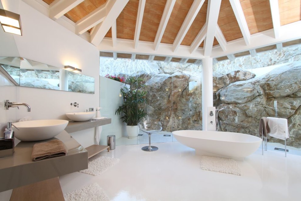 Стильный дизайн: огромная главная ванная комната в современном стиле с открытыми фасадами, коричневыми фасадами, отдельно стоящей ванной, белыми стенами, настольной раковиной, столешницей из искусственного камня и душем над ванной - последний тренд