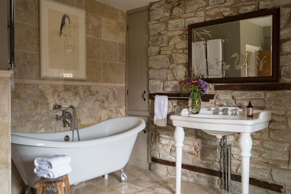 Kleines Duschbad mit Löwenfuß-Badewanne, Steinplatten, beiger Wandfarbe, beigen Fliesen, Waschtischkonsole und beigem Boden in Sonstige