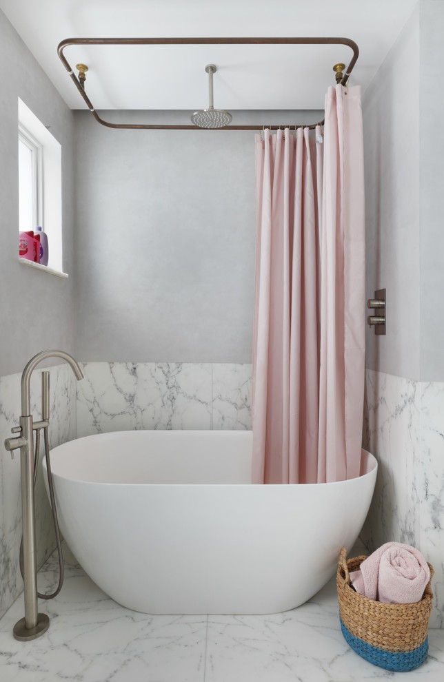 Immagine di una stanza da bagno minimal di medie dimensioni con vasca freestanding, piastrelle di marmo, pareti grigie, pavimento in marmo e pavimento bianco