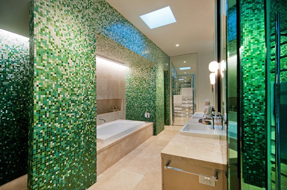 Idées déco pour une grande salle de bain principale contemporaine avec des portes de placard beiges, une baignoire posée, une douche double, un sol en marbre, un placard en trompe-l'oeil, WC suspendus, un carrelage vert, mosaïque, un mur beige, un lavabo posé et un plan de toilette en surface solide.