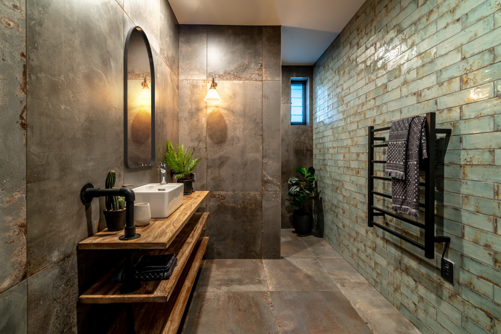 Пример оригинального дизайна: ванная комната среднего размера в стиле лофт с душем в нише, зеленой плиткой, керамической плиткой, полом из керамической плитки, столешницей из дерева, серым полом, открытым душем, коричневой столешницей и настольной раковиной