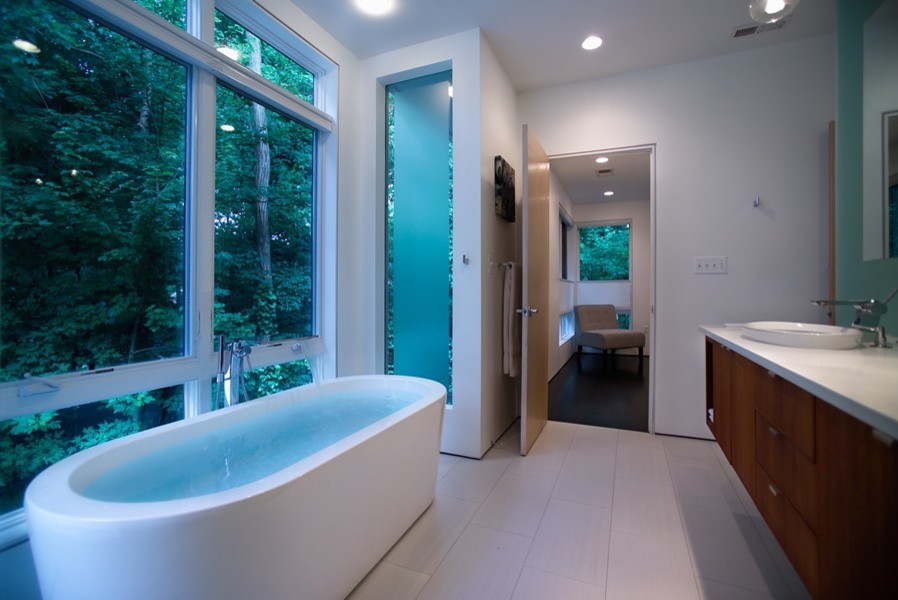 Immagine di una stanza da bagno padronale contemporanea di medie dimensioni con lavabo a bacinella, ante in legno scuro, top in superficie solida, vasca freestanding, pareti bianche e pavimento con piastrelle in ceramica