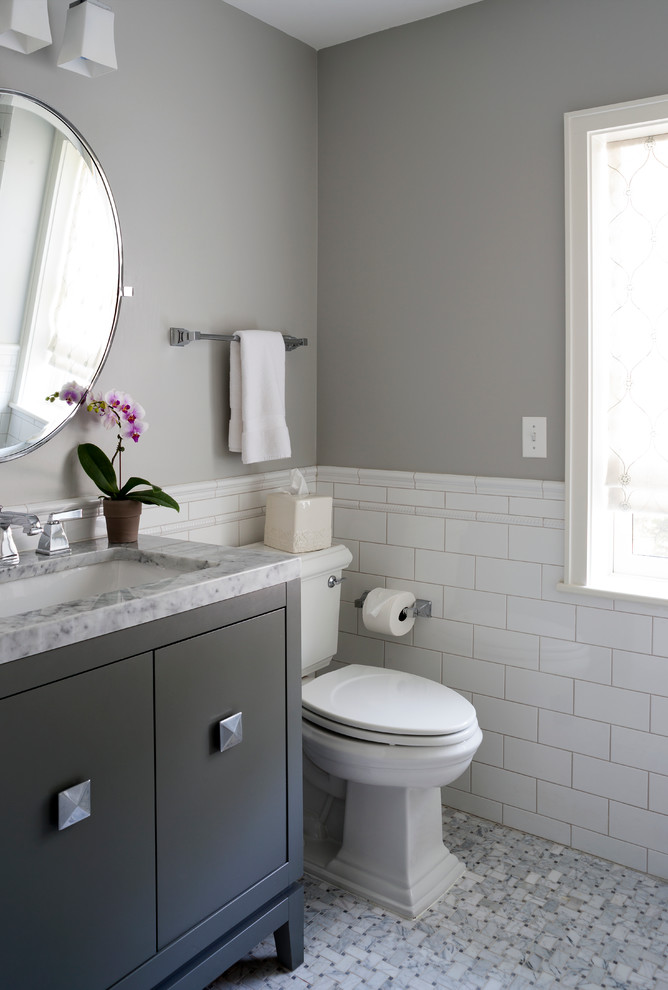 Bild på ett mellanstort vintage badrum med dusch, med en toalettstol med separat cisternkåpa, keramikplattor, grå väggar, mosaikgolv, marmorbänkskiva, vit kakel, ett undermonterad handfat, svarta skåp och släta luckor