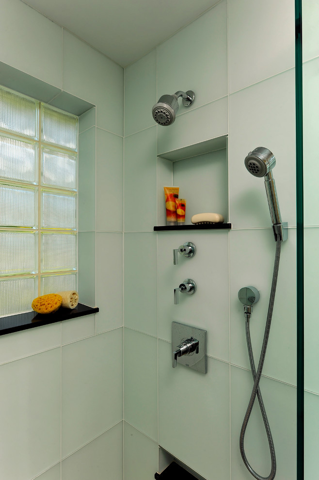 Идея дизайна: главная ванная комната среднего размера в современном стиле с плоскими фасадами, светлыми деревянными фасадами, угловой ванной, угловым душем, синими стенами, полом из мозаичной плитки, врезной раковиной, раздельным унитазом, зеленой плиткой, стеклянной плиткой, стеклянной столешницей, синим полом и душем с распашными дверями