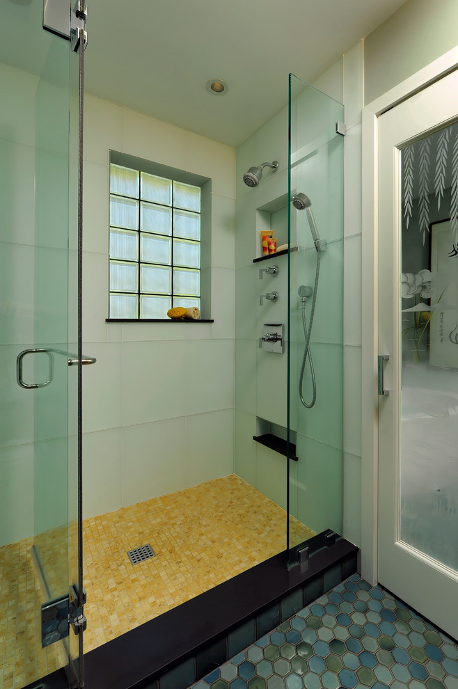 Свежая идея для дизайна: главная ванная комната среднего размера в современном стиле с плоскими фасадами, светлыми деревянными фасадами, угловой ванной, угловым душем, синими стенами, полом из мозаичной плитки, врезной раковиной, раздельным унитазом, зеленой плиткой, стеклянной плиткой, стеклянной столешницей, синим полом и душем с распашными дверями - отличное фото интерьера