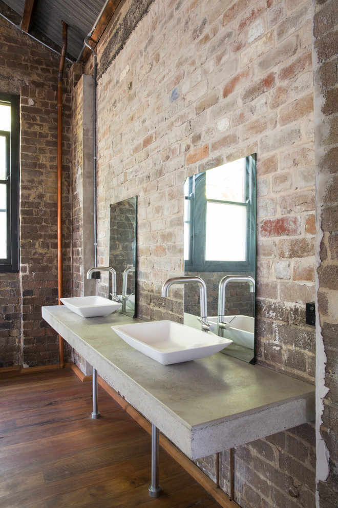 シドニーにあるインダストリアルスタイルのおしゃれな浴室 (置き型浴槽、コンクリートの洗面台、オープンシャワー) の写真