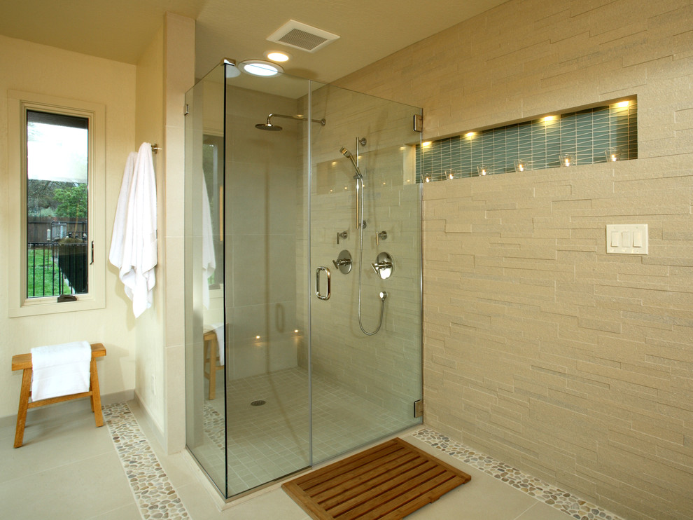 Пример оригинального дизайна: большая главная ванная комната в современном стиле с угловым душем, каменной плиткой, полом из галечной плитки, бежевой плиткой, унитазом-моноблоком, бежевыми стенами, плоскими фасадами и врезной раковиной
