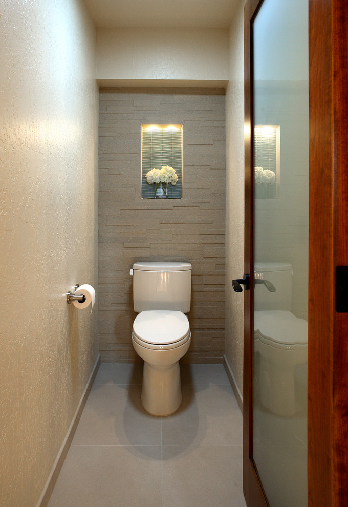 Immagine di un grande bagno di servizio design con ante lisce, ante in legno scuro, WC monopezzo, piastrelle beige, pareti beige e lavabo sottopiano