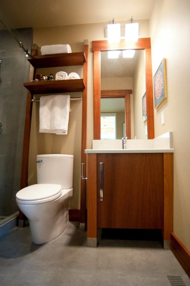 Exemple d'une salle de bain moderne en bois brun de taille moyenne avec un lavabo encastré, un placard à porte plane, un plan de toilette en quartz modifié, WC à poser, un carrelage gris, des carreaux de porcelaine et un sol en carrelage de porcelaine.