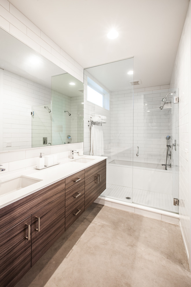 Foto de cuarto de baño actual con lavabo bajoencimera, armarios con paneles lisos, puertas de armario de madera en tonos medios, combinación de ducha y bañera, baldosas y/o azulejos blancos y baldosas y/o azulejos de cemento