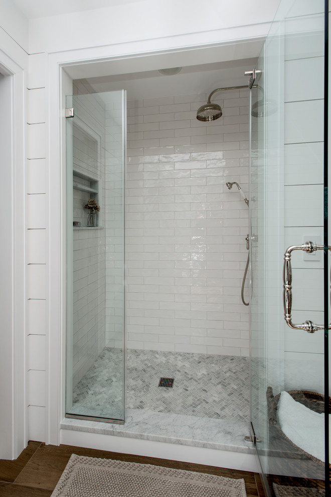 Modelo de cuarto de baño principal de tamaño medio con puertas de armario con efecto envejecido, ducha empotrada, baldosas y/o azulejos blancos, suelo de baldosas de porcelana, lavabo bajoencimera y suelo marrón
