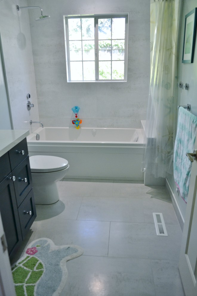 Foto på ett mellanstort vintage vit badrum för barn, med skåp i shakerstil, blå skåp, ett badkar i en alkov, vit kakel, keramikplattor, blå väggar, klinkergolv i porslin, ett undermonterad handfat, granitbänkskiva och vitt golv