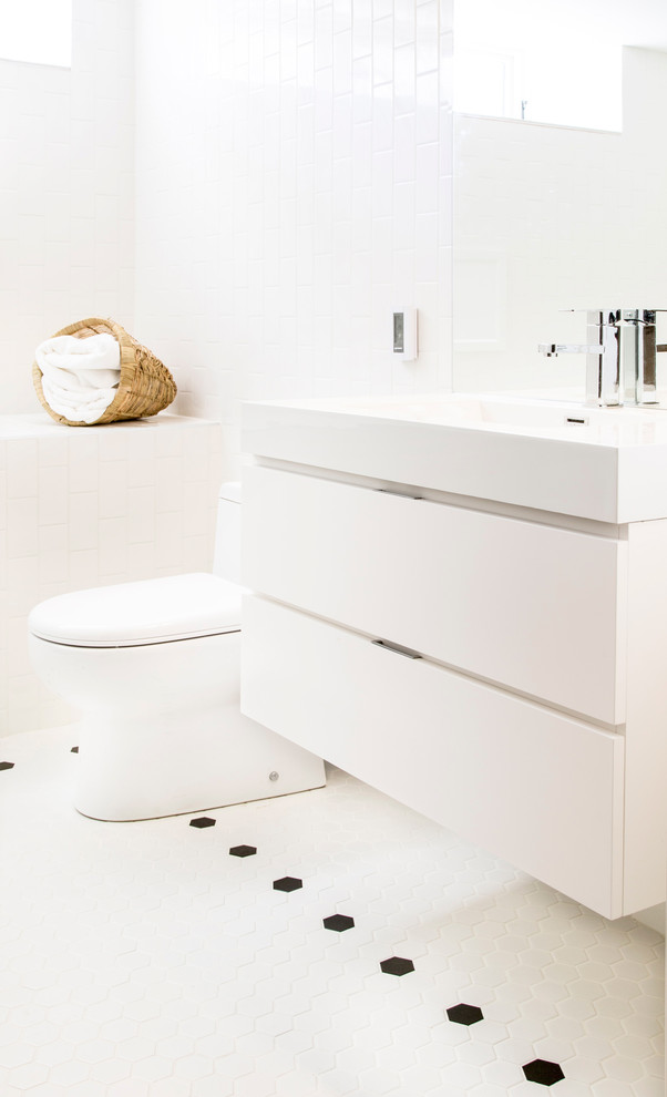 Diseño de cuarto de baño actual con armarios con paneles lisos, puertas de armario blancas y lavabo integrado