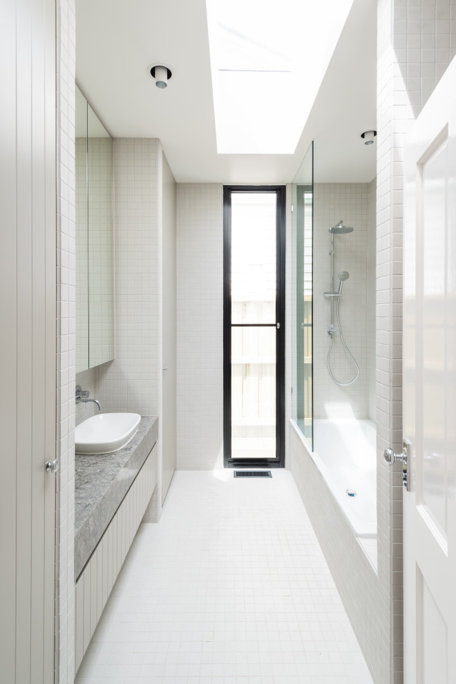 На фото: маленькая детская ванная комната со стиральной машиной в скандинавском стиле с плоскими фасадами, серыми фасадами, накладной ванной, душем над ванной, инсталляцией, белой плиткой, керамогранитной плиткой, белыми стенами, полом из керамогранита, накладной раковиной, столешницей из гранита, белым полом, открытым душем, серой столешницей, тумбой под одну раковину и встроенной тумбой для на участке и в саду