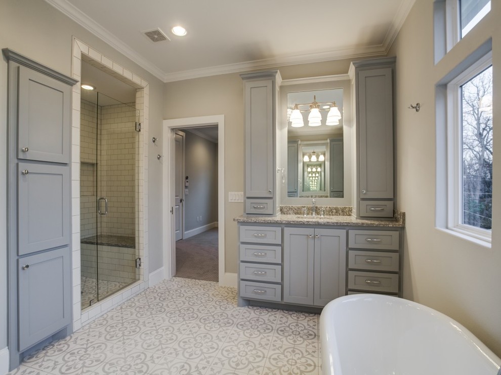 Идея дизайна: большая главная ванная комната в современном стиле с фасадами в стиле шейкер, серыми фасадами, отдельно стоящей ванной, душем в нише, белой плиткой, плиткой кабанчик, бежевыми стенами, полом из цементной плитки, врезной раковиной, столешницей из гранита, разноцветным полом и душем с распашными дверями