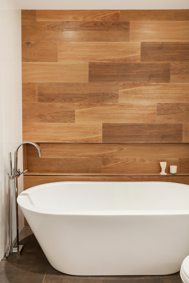 Réalisation d'une salle de bain principale tradition en bois clair de taille moyenne avec une baignoire indépendante, un placard à porte plane, un mur blanc, un sol en ardoise et un plan de toilette en surface solide.