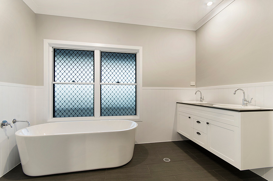 Design ideas for a classic ensuite bathroom in Townsville with shaker cabinets, white cabinets, a freestanding bath, grey walls, ceramic flooring, a built-in sink and grey floors.