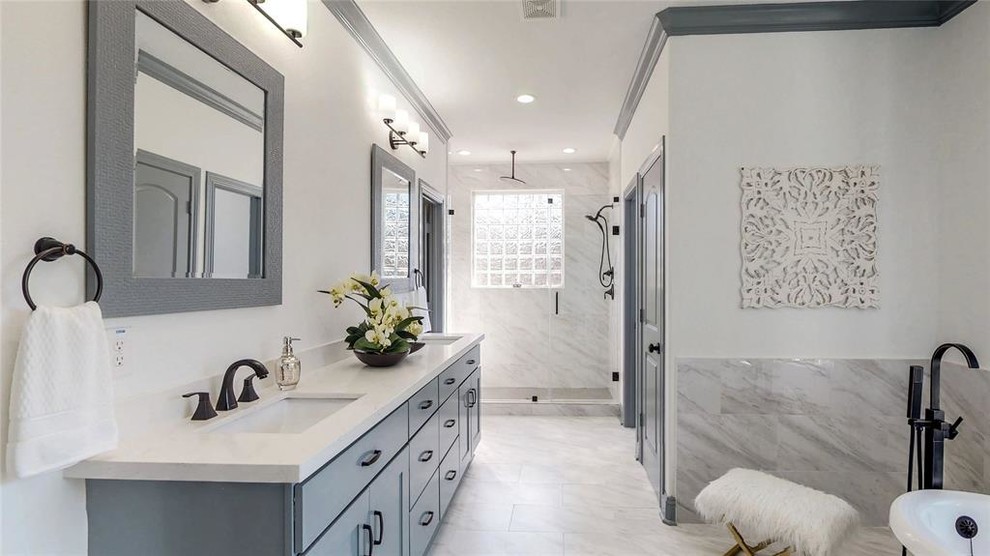 Photo of a large modern ensuite bathroom in Houston with shaker cabinets, grey cabinets, a freestanding bath, an alcove shower, white tiles, ceramic tiles, white walls, porcelain flooring, a vessel sink, quartz worktops, white floors, a hinged door and white worktops.