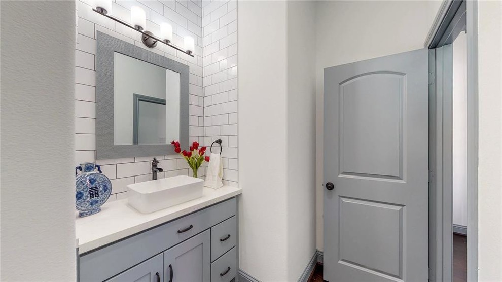 Foto på ett litet funkis vit badrum med dusch, med skåp i shakerstil, grå skåp, vit kakel, keramikplattor, vita väggar, laminatgolv, ett fristående handfat, bänkskiva i kvartsit och brunt golv