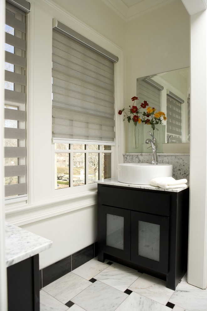 Inredning av ett modernt litet badrum med dusch, med luckor med glaspanel, svarta skåp, en toalettstol med hel cisternkåpa, svart och vit kakel, marmorkakel, vita väggar, marmorgolv, ett fristående handfat, marmorbänkskiva och vitt golv