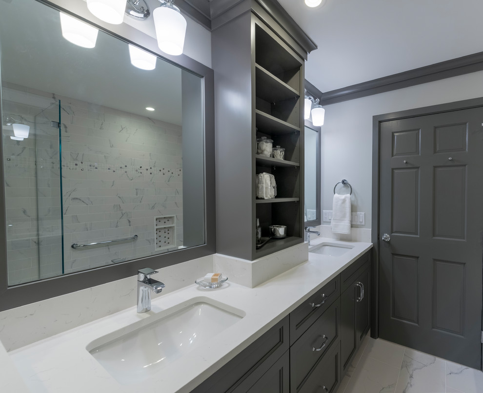 Example of a transitional kids' white tile and porcelain tile porcelain tile and white floor drop-in bathtub design in Boston with recessed-panel cabinets, gray cabinets, a one-piece toilet, blue walls, an undermount sink, quartz countertops and a hinged shower door