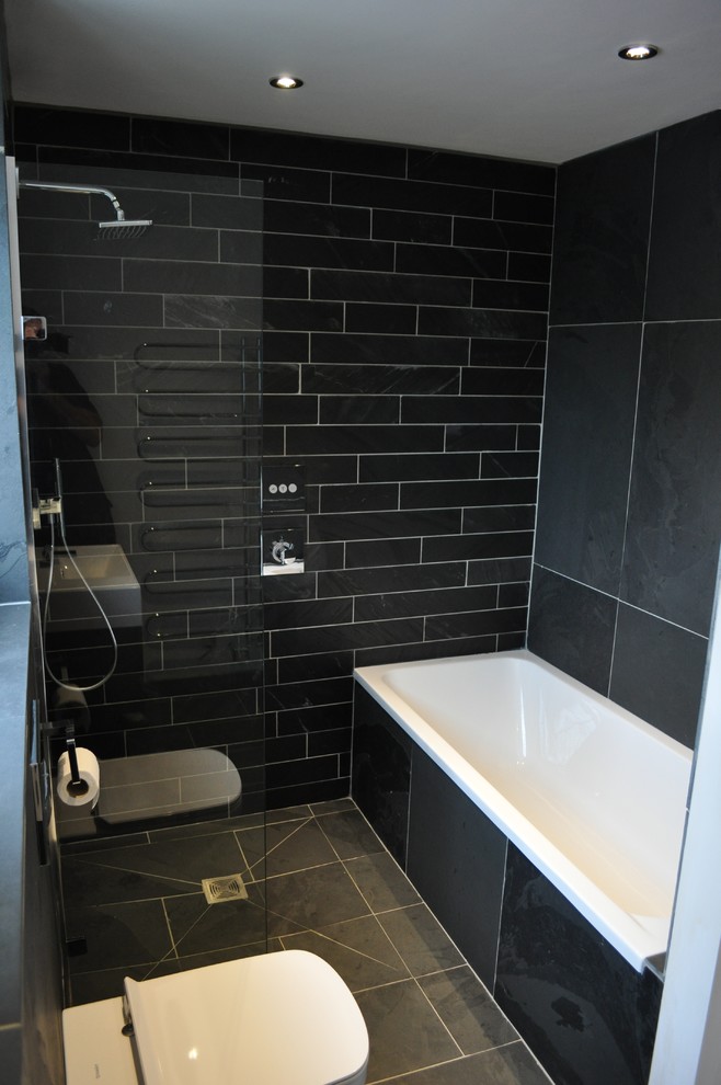 Пример оригинального дизайна: детская ванная комната среднего размера в стиле модернизм с плоскими фасадами, накладной ванной, открытым душем, инсталляцией, черной плиткой, каменной плиткой, черными стенами, полом из сланца, подвесной раковиной и серыми фасадами