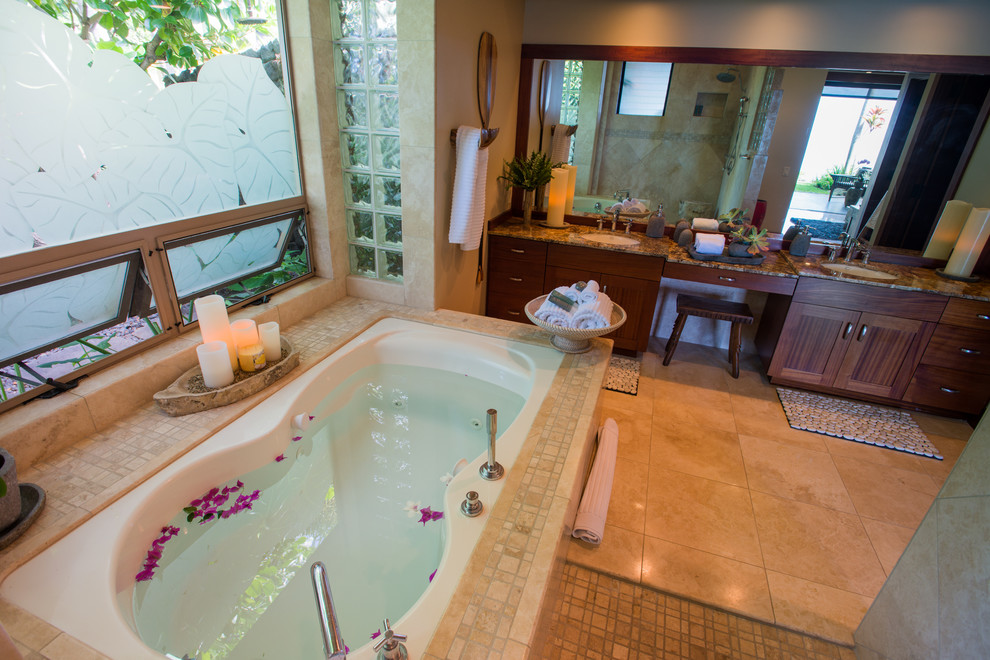 Example of a large island style master beige tile and stone tile limestone floor bathroom design in Hawaii with shaker cabinets, dark wood cabinets, a hot tub, beige walls, an undermount sink and granite countertops