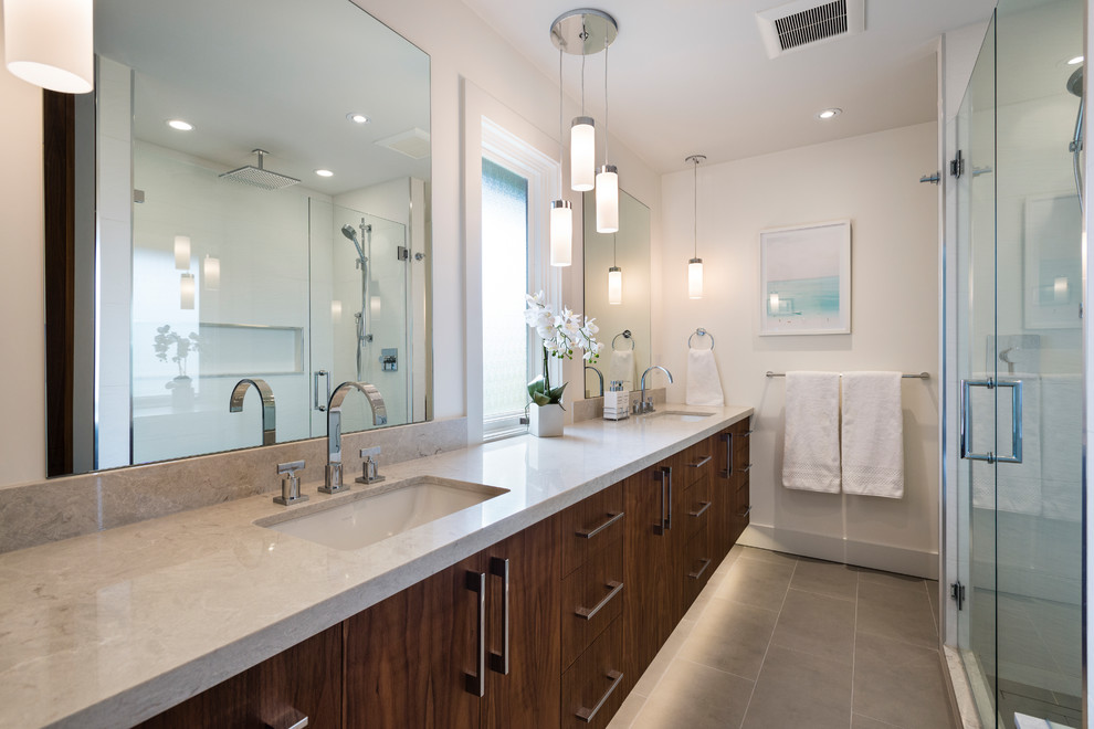 Bathroom - mid-sized transitional master white tile and porcelain tile porcelain tile and beige floor bathroom idea in Vancouver with flat-panel cabinets, brown cabinets, a two-piece toilet, beige walls, an undermount sink, quartz countertops and a hinged shower door