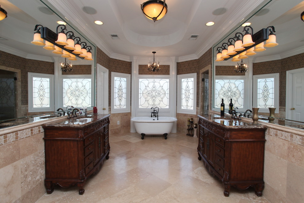Стильный дизайн: большая главная ванная комната в классическом стиле с фасадами островного типа, темными деревянными фасадами, ванной на ножках, бежевой плиткой и врезной раковиной - последний тренд