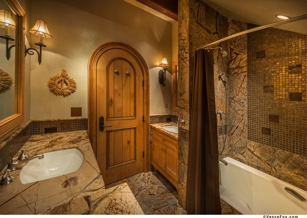 Photo of a medium sized rustic bathroom in Sacramento with a built-in sink, raised-panel cabinets, a built-in bath, multi-coloured tiles, stone tiles and multi-coloured walls.