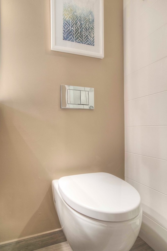 Mid-sized minimalist white tile and porcelain tile porcelain tile powder room photo in Denver with beige walls and a wall-mount toilet