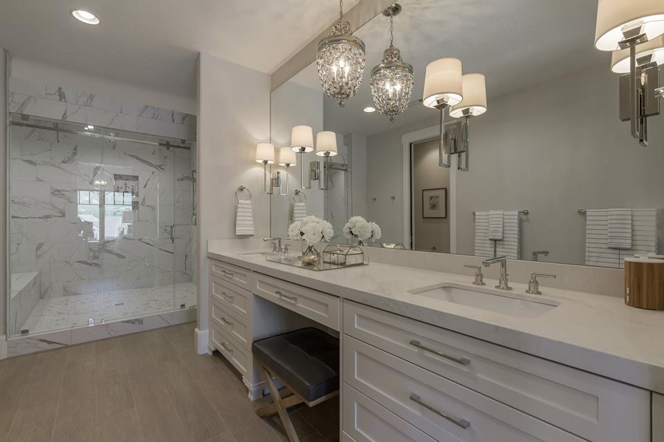 Photo of a large classic ensuite bathroom in Salt Lake City with a submerged sink, shaker cabinets, white cabinets, marble worktops, a two-piece toilet, white walls, light hardwood flooring, an alcove bath, an alcove shower, white tiles, marble tiles, brown floors and a hinged door.