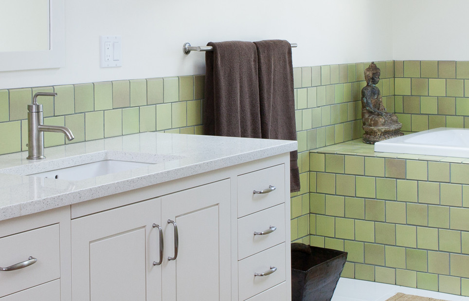 Idéer för ett modernt badrum, med ett undermonterad handfat, vita skåp, bänkskiva i återvunnet glas, grön kakel, ett badkar i en alkov, tunnelbanekakel, vita väggar och ljust trägolv