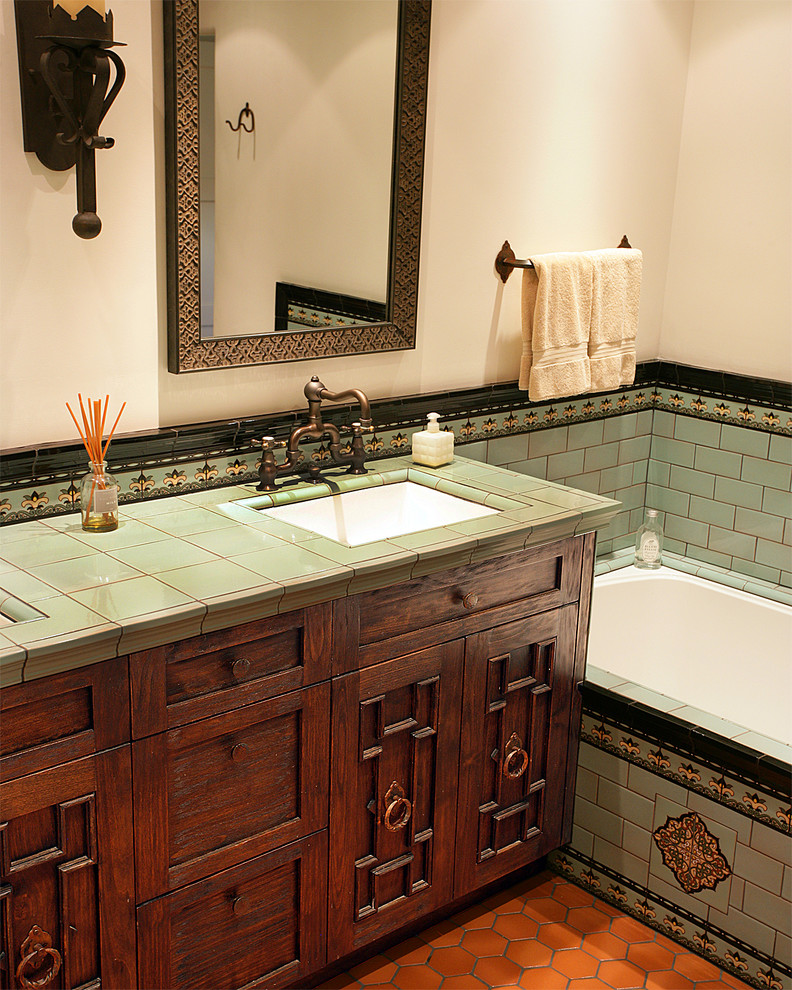 Стильный дизайн: главная ванная комната среднего размера в средиземноморском стиле с фасадами с выступающей филенкой, полновстраиваемой ванной, разноцветной плиткой, керамической плиткой, бежевыми стенами, полом из терракотовой плитки, врезной раковиной, столешницей из плитки, коричневым полом и зеленой столешницей - последний тренд