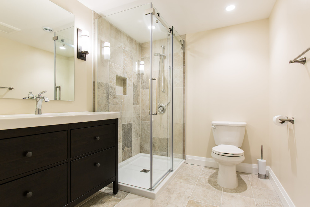Inspiration for a medium sized contemporary shower room bathroom in Ottawa with freestanding cabinets, dark wood cabinets, a corner shower, a two-piece toilet, beige tiles, porcelain tiles, beige walls, porcelain flooring, a trough sink and solid surface worktops.