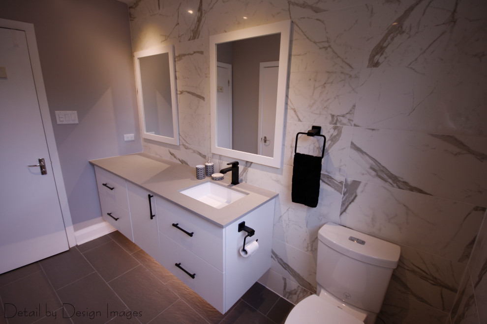 Photo of a medium sized contemporary family bathroom in Ottawa with flat-panel cabinets, white cabinets, an alcove bath, a shower/bath combination, a one-piece toilet, black and white tiles, porcelain tiles, white walls, porcelain flooring, a submerged sink, engineered stone worktops, grey floors, a sliding door, grey worktops, a single sink and a floating vanity unit.