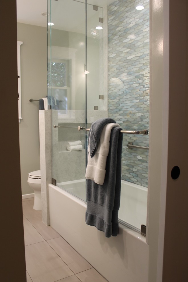 На фото: ванная комната среднего размера в стиле ретро с фасадами в стиле шейкер, белыми фасадами, ванной в нише, душем над ванной, раздельным унитазом, разноцветной плиткой, плиткой из листового стекла, бежевыми стенами, полом из керамогранита, подвесной раковиной, столешницей из искусственного кварца, серым полом, душем с распашными дверями и белой столешницей с