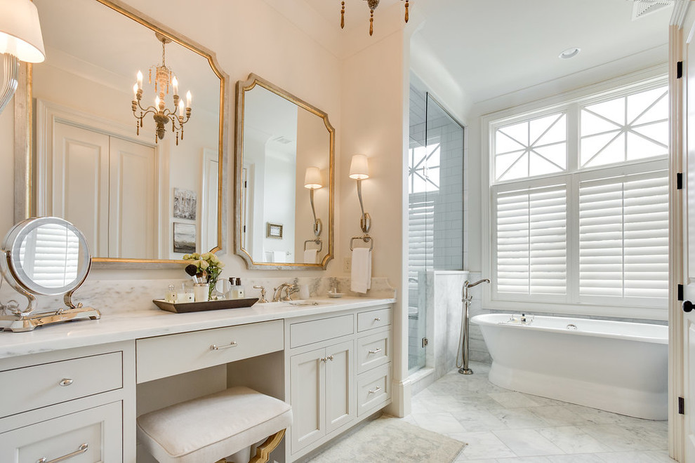 Стильный дизайн: главная ванная комната в классическом стиле с бежевыми фасадами, отдельно стоящей ванной, душем в нише, белой плиткой, бежевыми стенами, белым полом и душем с распашными дверями - последний тренд