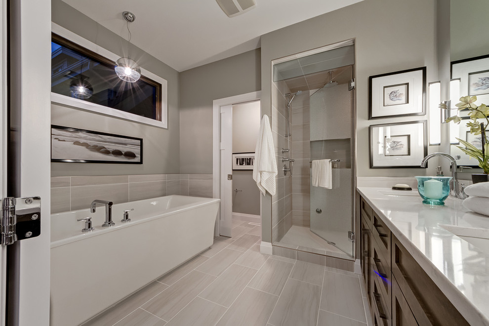 Freestanding bathtub - large transitional master gray tile and porcelain tile porcelain tile freestanding bathtub idea in Calgary with shaker cabinets, medium tone wood cabinets, quartz countertops and gray walls