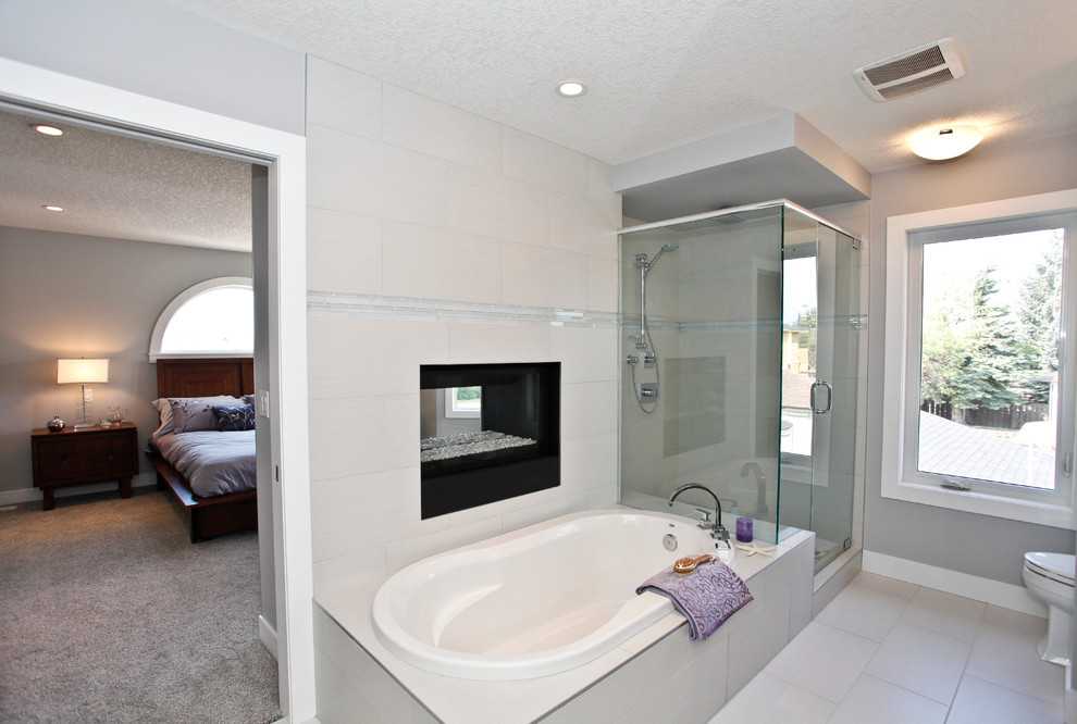Ispirazione per una stanza da bagno padronale contemporanea di medie dimensioni con ante lisce, ante grigie, vasca da incasso, doccia ad angolo, piastrelle beige, piastrelle in gres porcellanato, pareti grigie, pavimento in gres porcellanato, lavabo a bacinella e top in granito