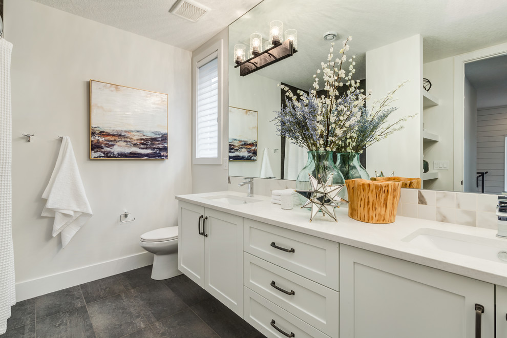 Bathroom - mid-sized cottage 3/4 concrete floor and gray floor bathroom idea in Calgary with shaker cabinets, white cabinets, a two-piece toilet, white walls, an undermount sink and quartzite countertops