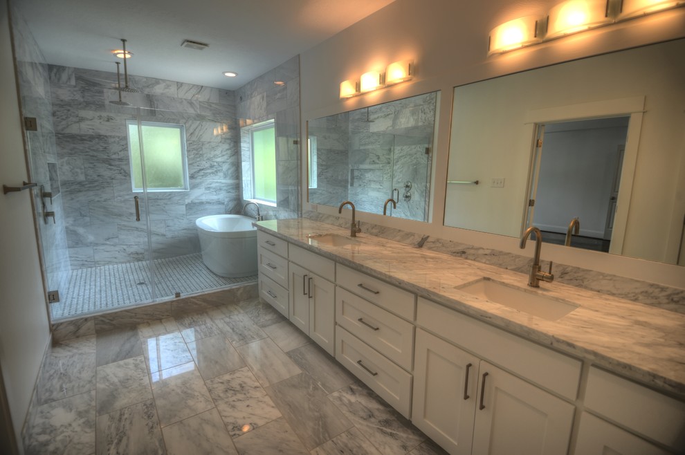 Photo of a large contemporary ensuite bathroom in Houston with shaker cabinets, white cabinets, marble worktops, a freestanding bath, a walk-in shower, a one-piece toilet, white tiles, stone tiles, white walls, marble flooring and a submerged sink.