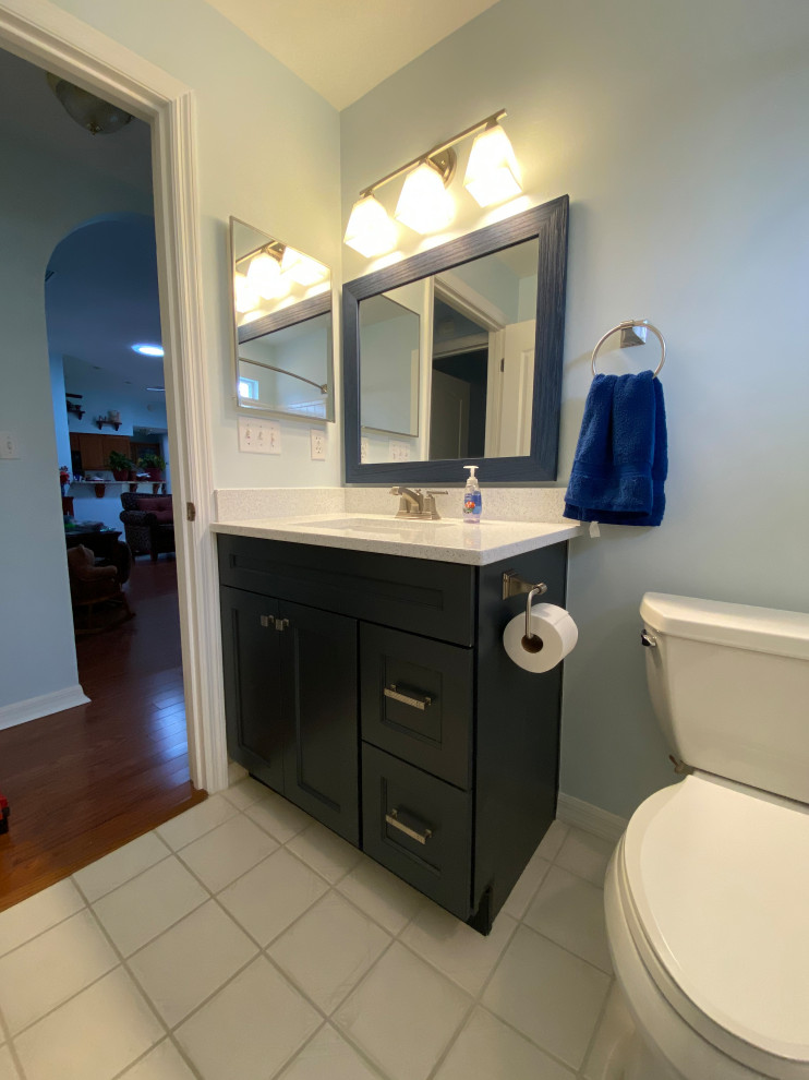 Idée de décoration pour une grande salle de bain principale minimaliste avec un placard à porte shaker, des portes de placard bleues, un mur bleu, un lavabo encastré, un plan de toilette en quartz et un plan de toilette blanc.