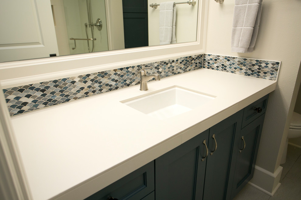 Exempel på ett mellanstort klassiskt badrum med dusch, med luckor med infälld panel, grå skåp, en dusch i en alkov, beige kakel, blå kakel, brun kakel, grå kakel, mosaik, grå väggar, laminatgolv, ett undermonterad handfat, grått golv och dusch med gångjärnsdörr