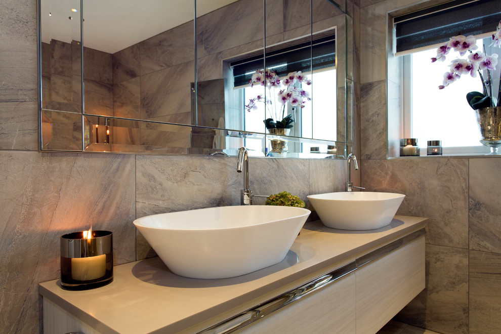 This is an example of a large classic ensuite bathroom in Other with raised-panel cabinets, beige cabinets, a freestanding bath, a walk-in shower, grey tiles and grey walls.