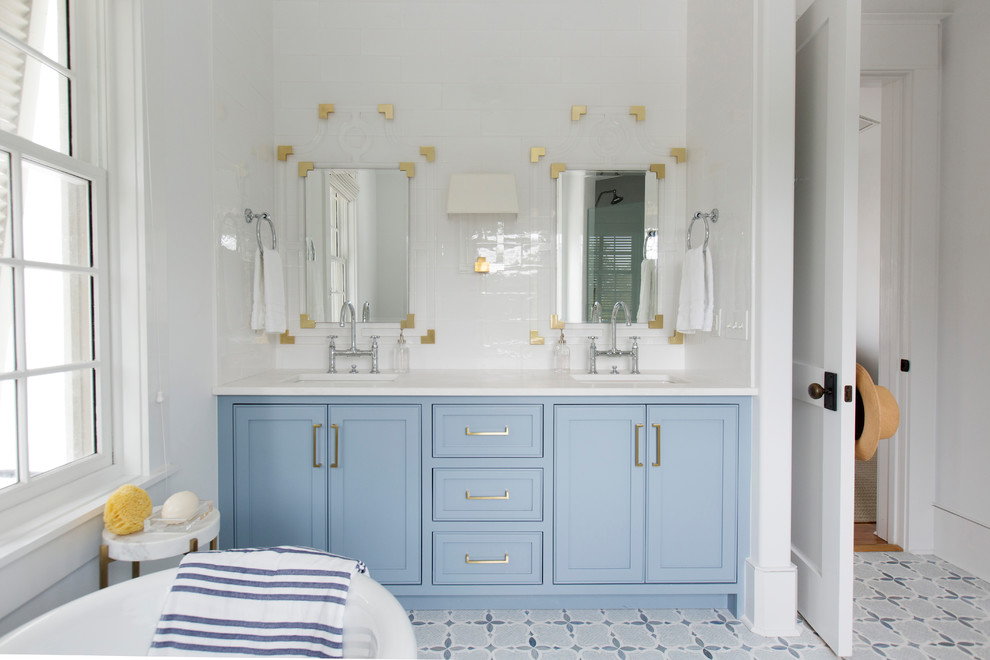 Immagine di una stanza da bagno costiera con vasca con piedi a zampa di leone, pareti bianche, lavabo sottopiano e pavimento blu