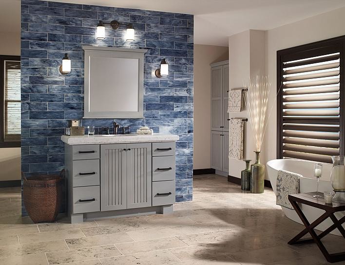 Exemple d'une grande salle de bain principale chic avec un placard à porte plane, des portes de placard grises, une baignoire indépendante, un carrelage bleu, un carrelage en pâte de verre, un mur beige, un lavabo encastré et un plan de toilette en granite.