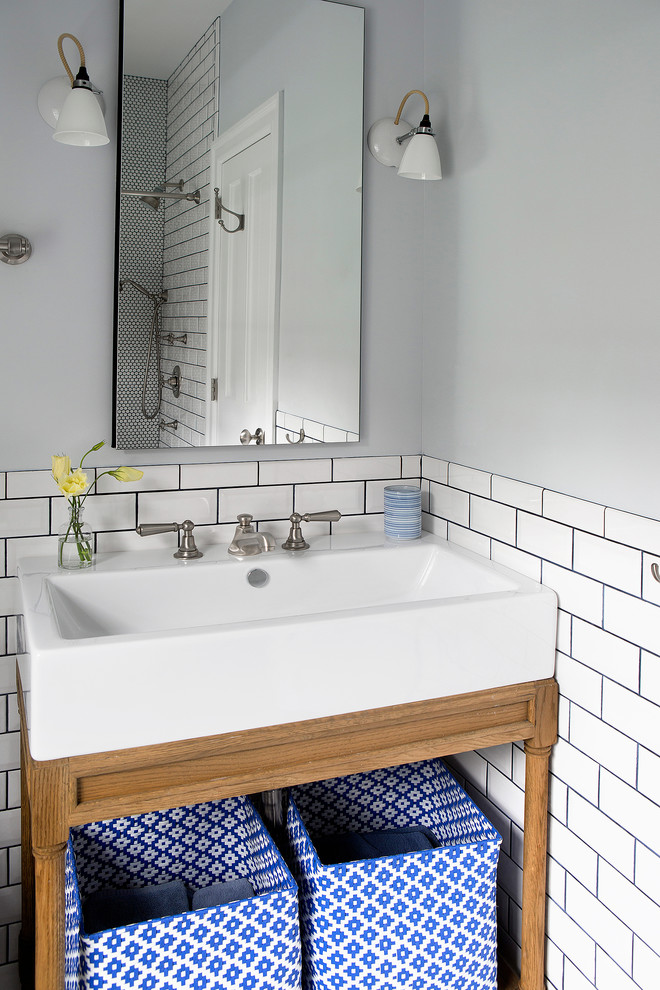 Inspiration for a small eclectic 3/4 white tile and ceramic tile bathroom remodel in New York with a console sink, furniture-like cabinets, medium tone wood cabinets, solid surface countertops, a one-piece toilet and blue walls