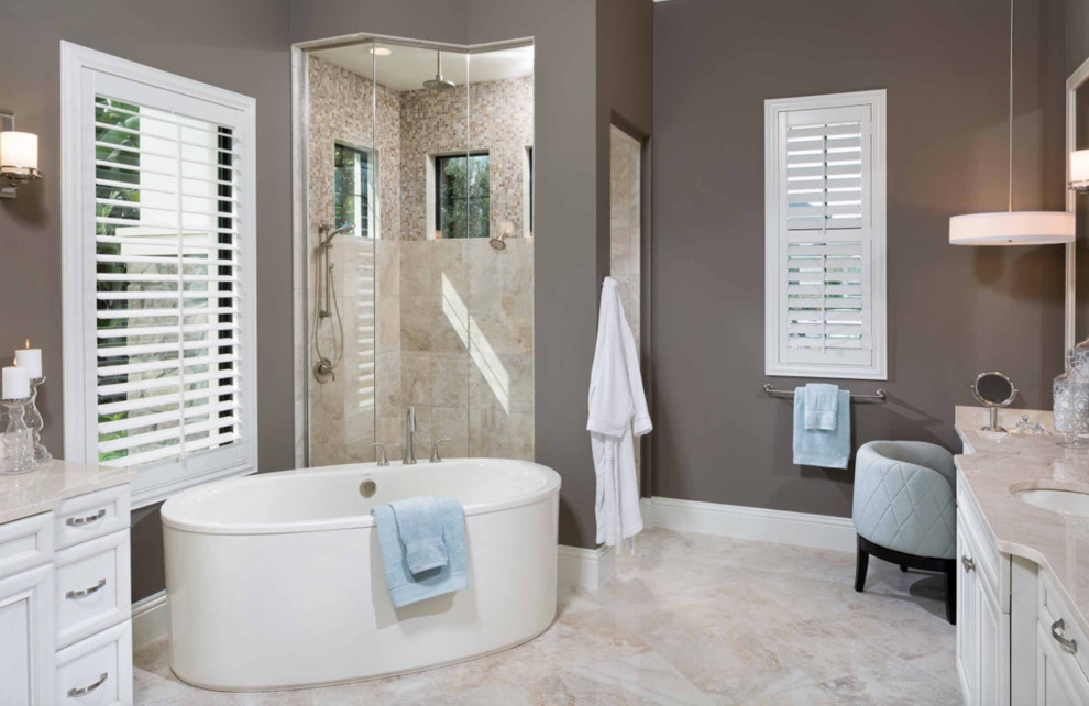 Klassisk inredning av ett stort en-suite badrum, med luckor med infälld panel, vita skåp, ett fristående badkar, en hörndusch, mosaik, bruna väggar, travertin golv, ett undermonterad handfat, marmorbänkskiva, beiget golv och dusch med gångjärnsdörr